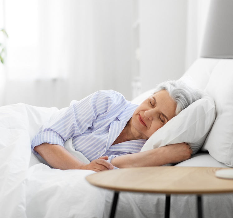 Senior woman sleeping in bed.
